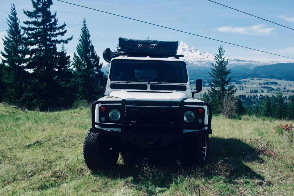 Front view of the Perentie 110 parked in a meadow with Mount Hood in the background