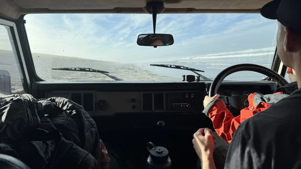 View from inside the cab looking through the windshield while driving on the beach