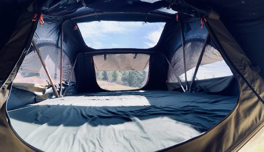 Interior view of the rooftop tent showing the sleeping area and skylight windows